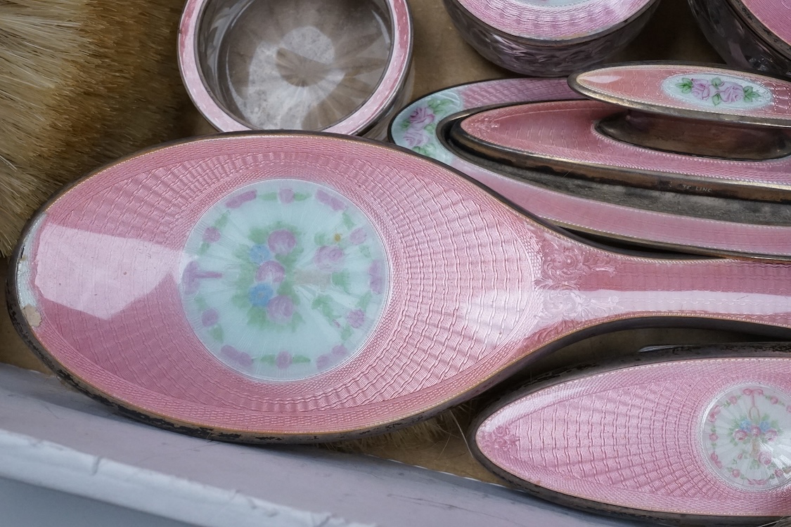 An early century North American sterling and enamel dressing table set by Theodore W. Foster & Bro, comprising fourteen items including hand mirror, 29.1cm, brushes, trinket box, nail buffer on stand, toilet jars, powder